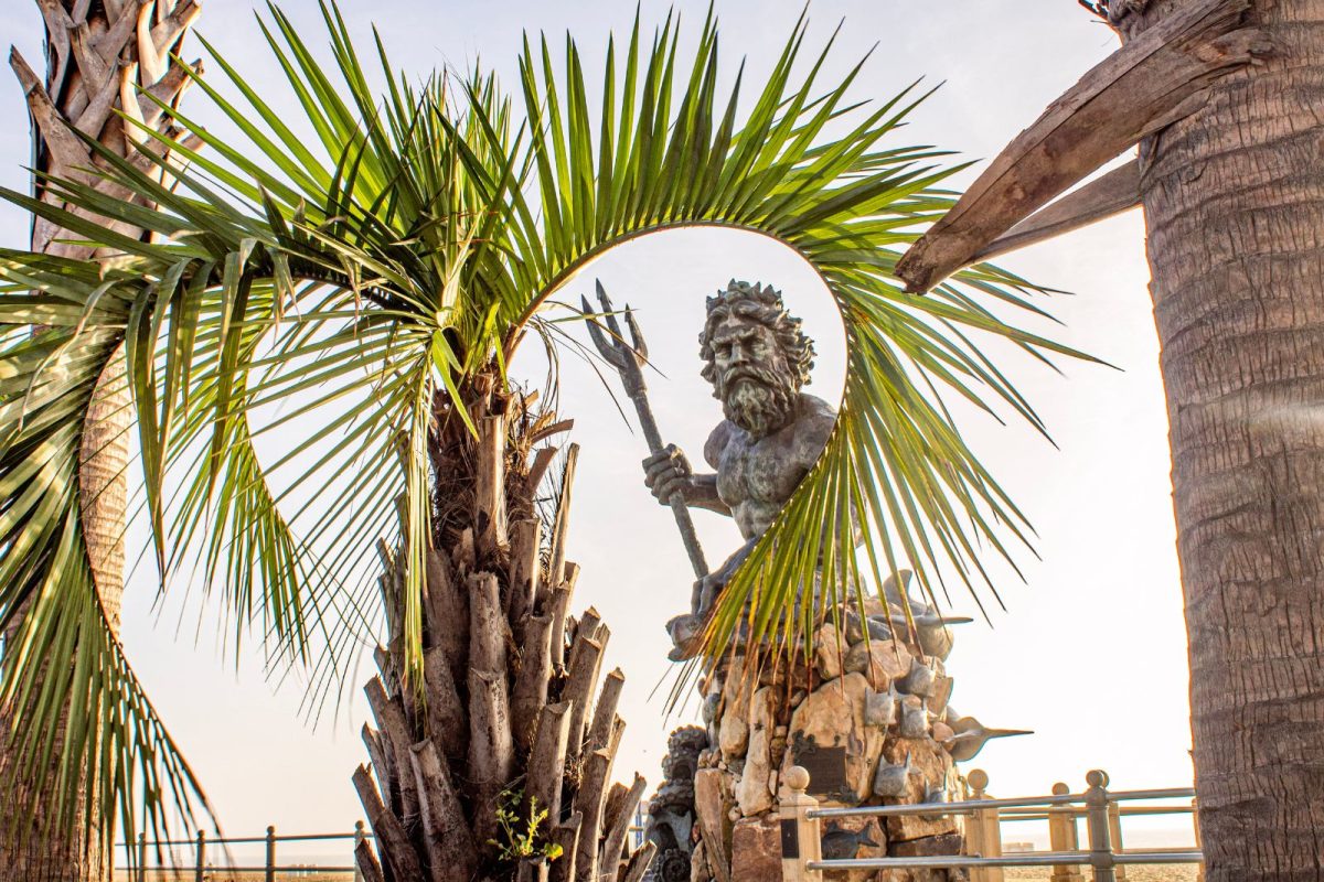 King Neptune statue seen through palm tree leaves in Virginia Beach, location of Neptune Festival, one of top camping events