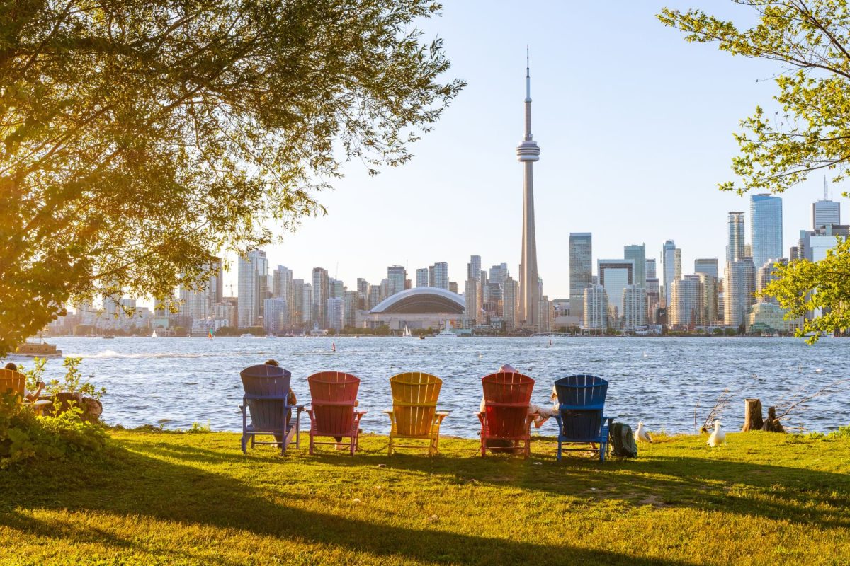 colorful Adirondack chairs facing Toronto city skyline