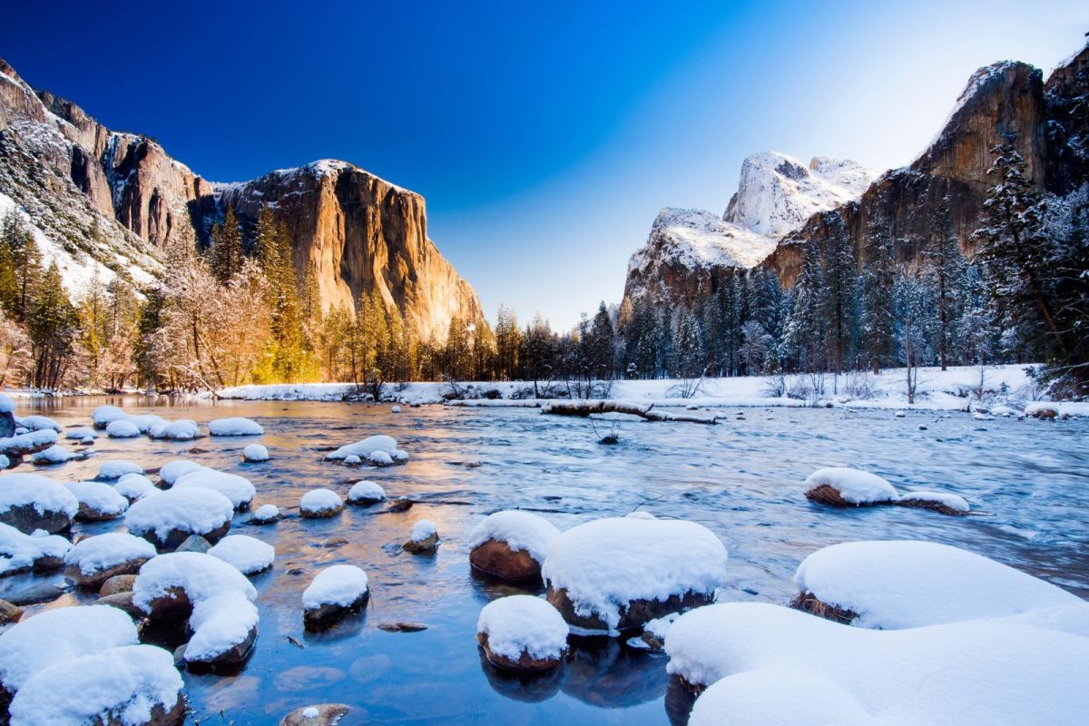 Yosemite cliffs and river crusted with snow in winter