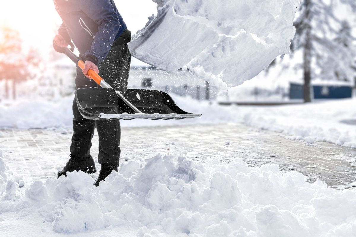 person using snow shovel to clear our space for winter RV camping